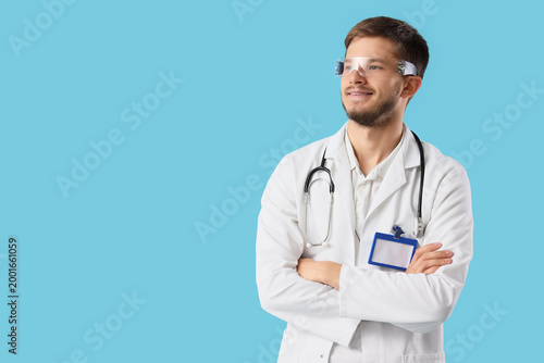 Male doctor in AR glasses on blue background