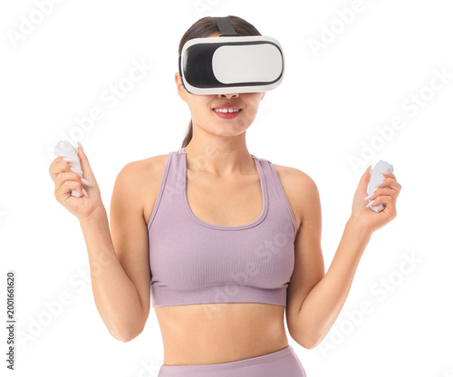 Sporty young woman in VR glasses exercising with controllers on white background