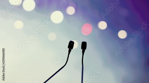 Dual Conference Microphones on Podium with Blurred Audience Background
