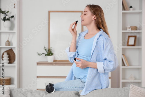 Young pregnant woman eating...