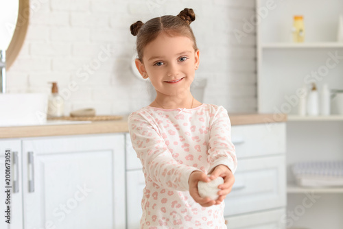 Little girl with soap bar in bathroom