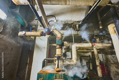Steam leaking from old boiler room pipes