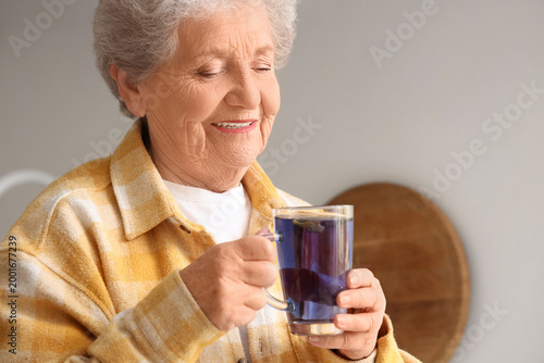 Senior woman with glass cup...
