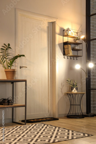 Εκτύπωση καμβά Interior of hall with glowing lamp, door and shelves in evening