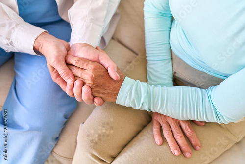 Senior Healthcare Support: Compassionate Nurse Holding Elderly Patient'S Hand, Offering Comfort And Medical Assistance