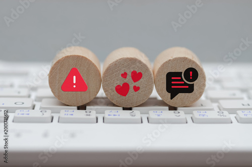 Online Safety Warning Icons on Wooden Blocks Over Computer Keyboard for Internet Security and Relationship Concept