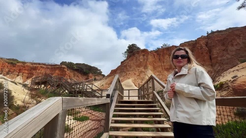close view of beautiful woman descends wooden steps in the midst of nature