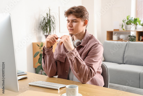 Male student with computer studying online at home