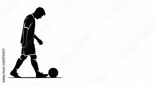 Silhouette of a soccer player standing with a ball