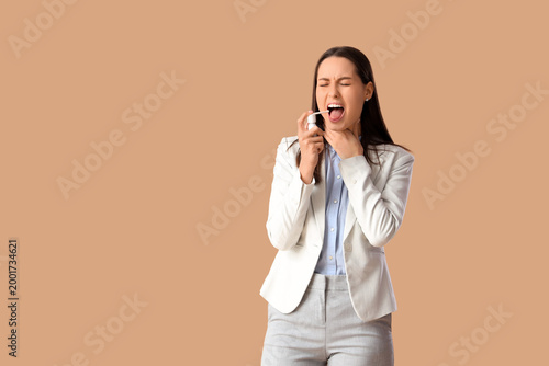 Young woman using spray for...