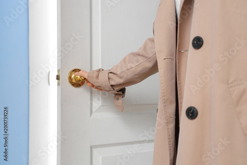 Fotografie Young woman closing door at home, closeup