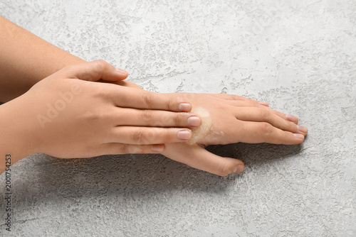 Woman applying scrub onto h...