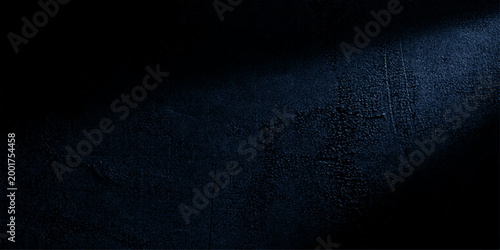 Dark blue abstract grunge background with a blank vintage chalkboard texture and dark stone concrete wall pattern for a textured old paper backdrop