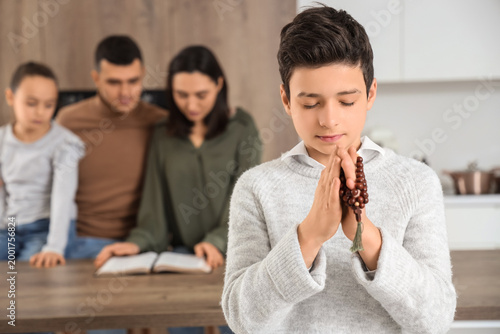 Little boy praying with bea...