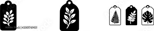 A black rectangular ceramic tag with a white leaf design on it is placed against a plain background