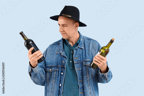 Mature man with bottles of ...