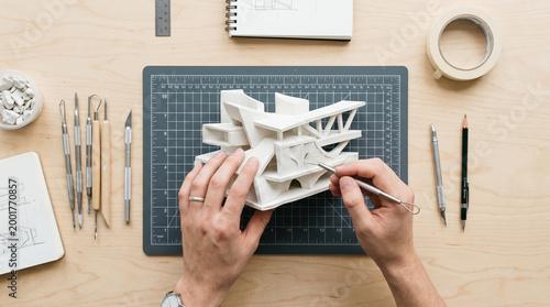 Artist hands sculpting white clay model on cutting mat with art