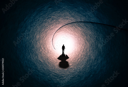 A man walks through a long tunnel toward a bright light. Topics: religion, God, soul, faith, light at the end of the tunnel, life after death, another world, freedom of choice, open mind, meditation.