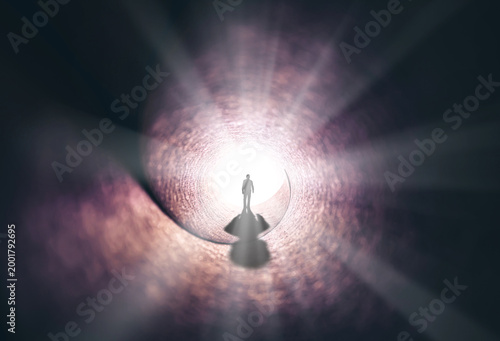 A man walks through a long tunnel toward a bright light. Topics: religion, God, soul, faith, light at the end of the tunnel, life after death, another world, freedom of choice, open mind, meditation.