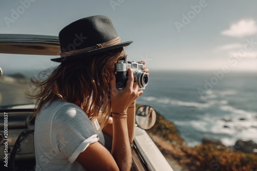 Woman in Hat Captures Coastal Scenery with Vintage Camera from Convertible.