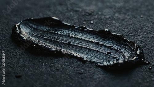 Black Oil Texture Smear on Dark Industrial Surface