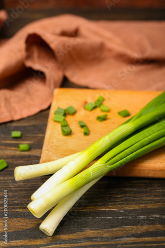 Fresh green onions on cutti...