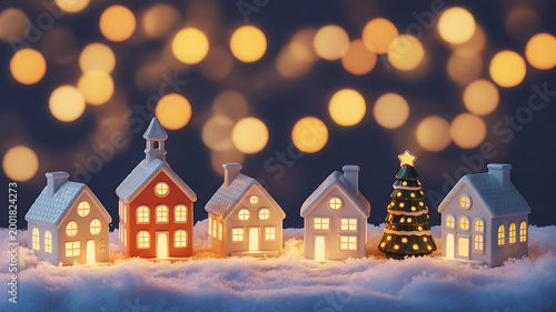Miniature houses and Christmas tree on snowy surface with bokeh lights  festive holiday scene