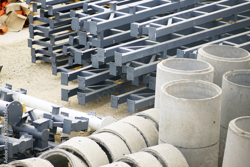 Quadro su tela Gray painted steel structural frames alongside upright precast concrete manhole rings prepared for sequential installation