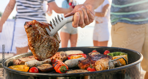 Man cooking tasty meat on b...