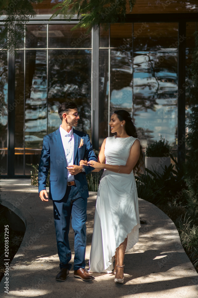 Obraz premium Happy bride and groom walking and embracing outdoors in romantic wedding setting