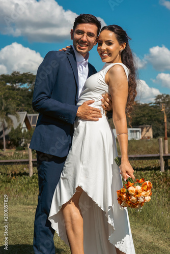 Schilderij op canvas Happy bride and groom walking and embracing outdoors in romantic wedding setting