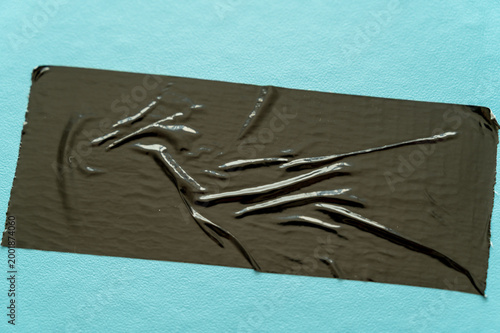 Folded adhesive tapes on a light blue background, minimal graphic texture with contrasts.