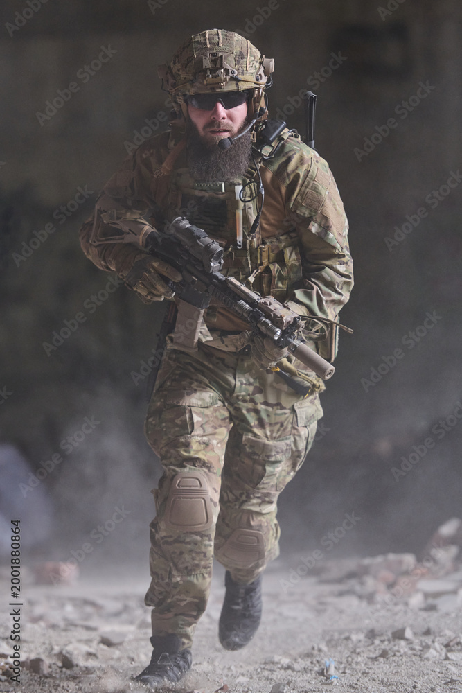 Fototapeta premium Armed Soldier in Camouflage Tactical Gear Running With Rifle During Urban Combat Operation