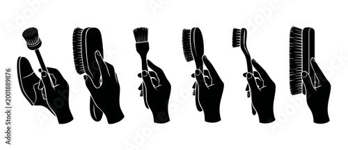 Hands holding cleaning brushes icon set, professional footwear maintenance and shoe care tools, isolated black silhouettes on white background for cleaning service instruction or hygiene manual design