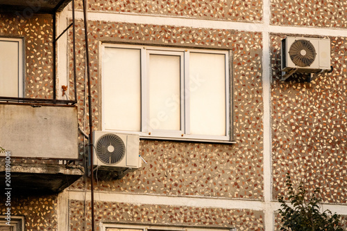 air conditioner, condenser unit, compressor on facade of building. unit of central AC conditioner of HVAC heating ventilation system. Indoor and office air cooling during seasonal temperature rise.