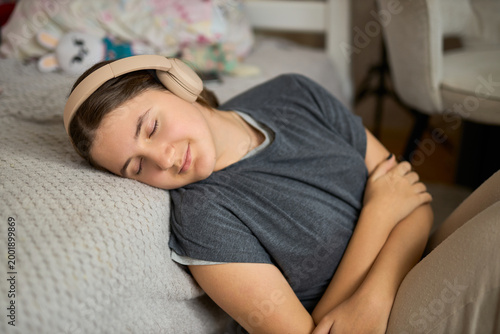 Teen girl relaxing with headphones eyes closed