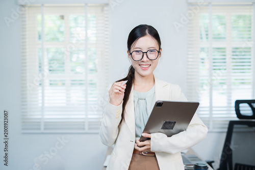 A successful Asian businesswoman, looking confident and smiling.