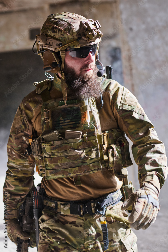 Fototapeta premium Bearded Soldier In Tactical Military Gear With Helmet And Rifle During Urban Operation
