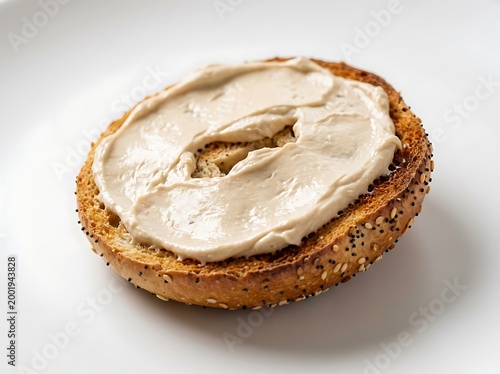 A toasted everything bagel half with cream cheese spread on top  a delicious breakfast or snack option