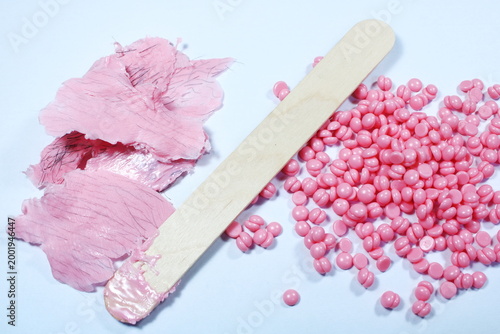 Photos Pink Hard Wax Beans With Wooden Spatula And Used Wax Strips For Hair Removal On