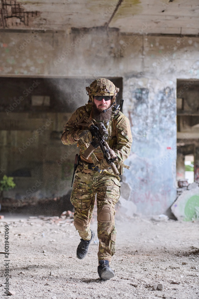 Obraz premium Armed Soldier Running Through Abandoned Building In Tactical Gear During Urban Combat Training Exercise