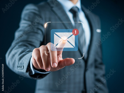 A businessman in a suit interacts with a digital email notification on a transparent screen with one hand