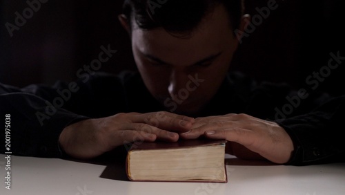 Принти на полотні Man showing deep faith and devotion, bowing his head while placing hands reveren
