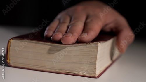 Canvas Print Person placing a hand on a holy book, symbolizing an oath, testimony, or witness