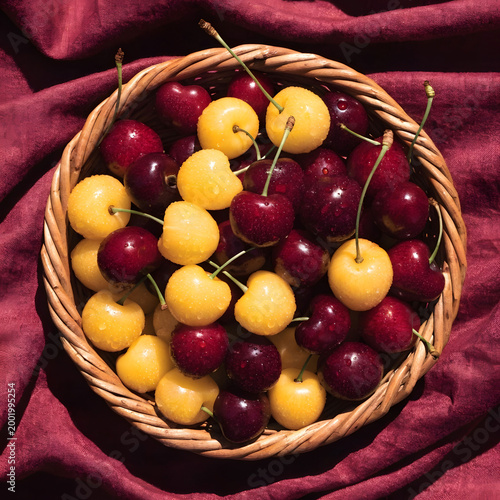 top view of basket full of yellow and red cherries