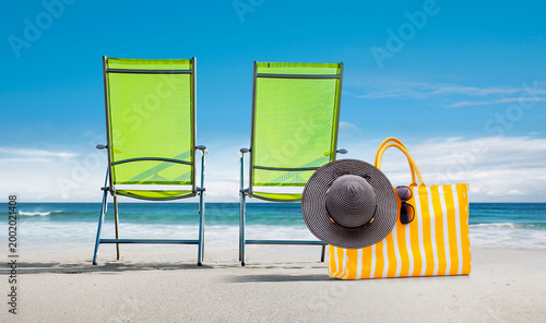 Zwei grüne Stühle am Strand
