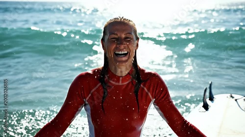 A surfer playfully hides behind a splash of ocean water while riding a wave, capturing a moment of joy and connection with the sea.