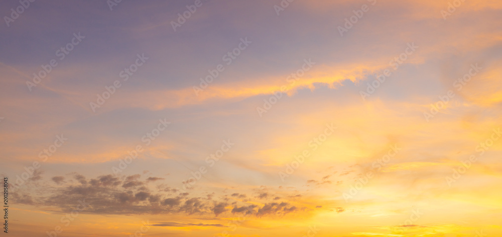 Fototapeta premium Beautiful sunset sky background with vibrant orange, pink, and blue colors,Breathtaking panoramic view of a dramatic sunset sky, featuring a stunning gradient of deep blue to fiery orange and soft.