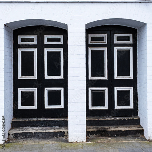 Two identical old wooden front doors