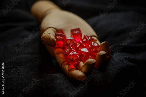 Cuadro en lienzo Wooden hand mannequin holding semi-transparent red role-playing game dice set